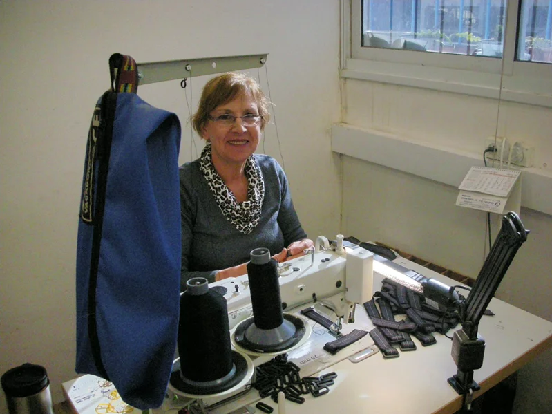 מנאל החייכנית תופרת רצועות לסנדלי שורש